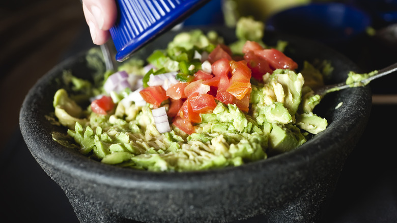 Guacamole in bowl topped with pico de gallo