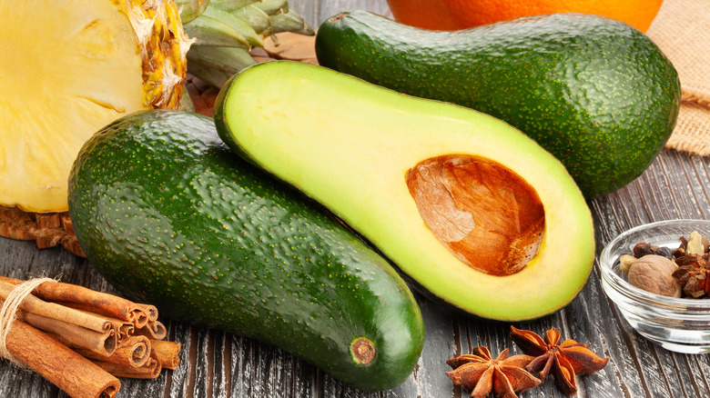 oblong avocado sliced in half around fall spices
