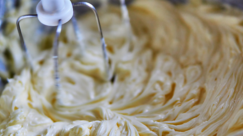 A stand mixer whips up butter to make buttercream