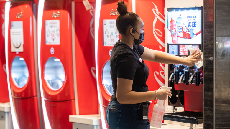 Employee cleans a soda machine