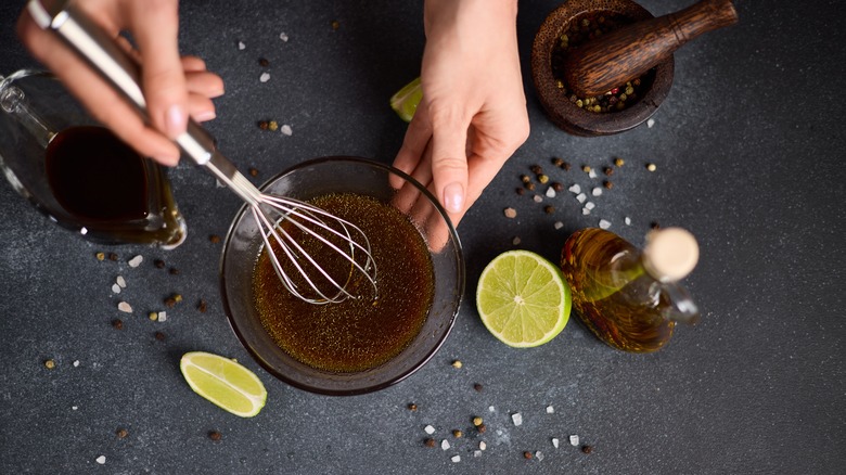 Woman whisking marinade in a glass bowl